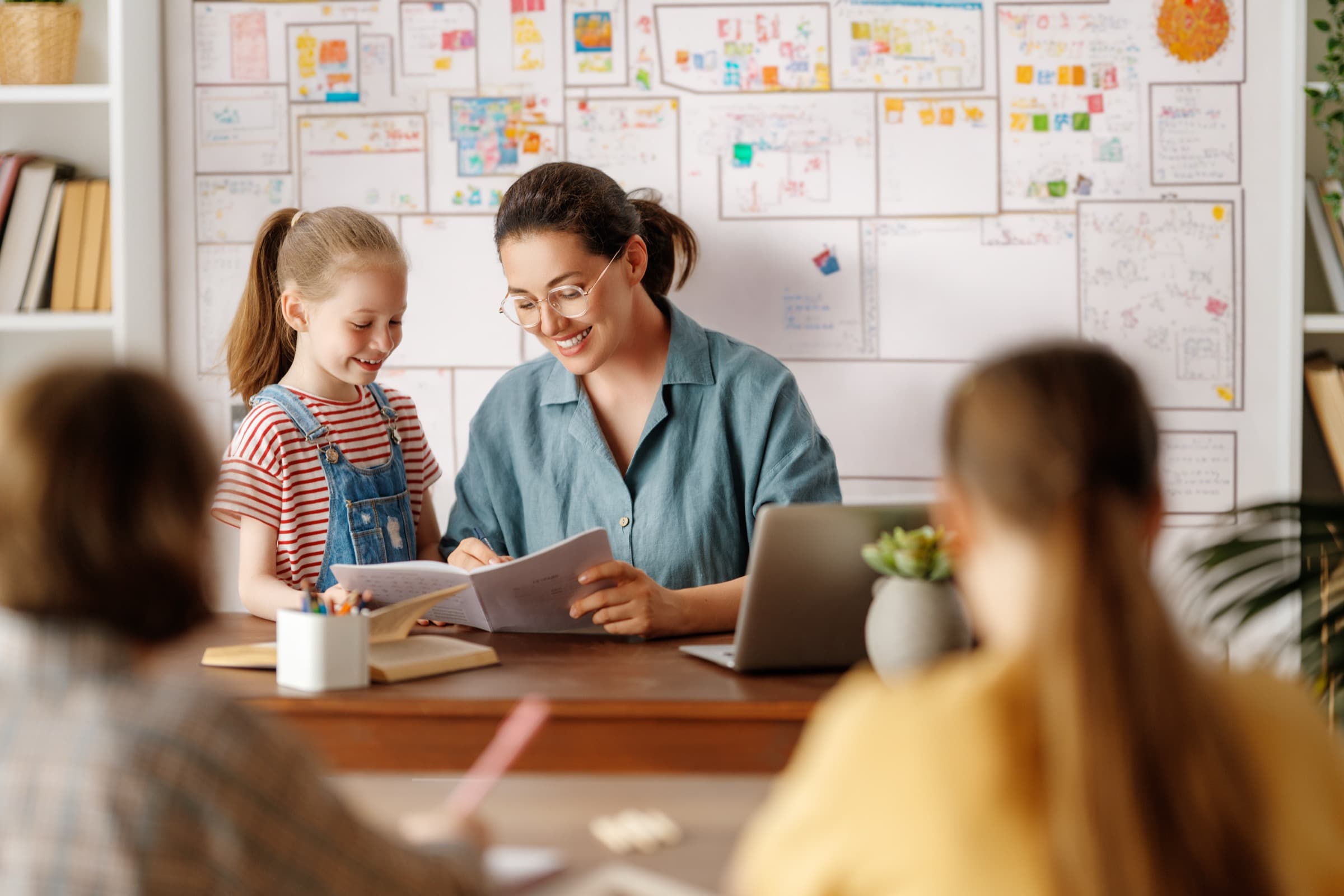A young student practising reading with a teacher